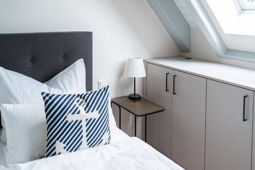 a bedroom with a bed with white sheets and a window at Haus Sandnelke - Domizil am Ostseewald in Zingst