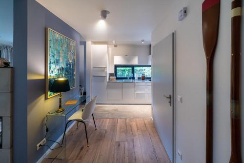 a living room with a desk and a kitchen at Haus Sandnelke - Domizil am Ostseewald in Zingst