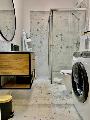a bathroom with a shower and a washing machine at REMAR - Apartments Lake Biale in Augustów