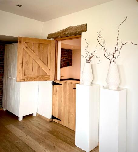 a kitchen with two white vases in a room at Landgoed Moerslag in Sint Geertruid