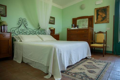 a bedroom with a white bed and a dresser at Agriturismo Petrara in Simeri