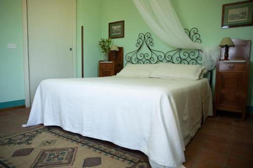 a bedroom with a large white bed with a canopy at Agriturismo Petrara in Simeri