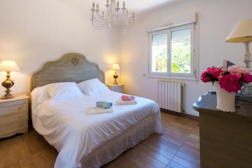 a bedroom with a bed with white sheets and pink flowers at Villa Roma in Prunelli-di-Fiumorbo