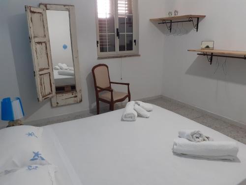 a white room with two towels and a chair at Villa Il Lupo in Pachino