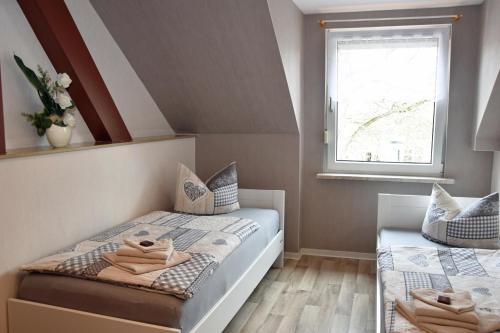 una piccola camera con due letti e una finestra di Ferienwohnung Wolf a Havelberg