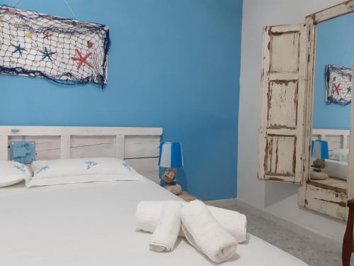 a blue bedroom with a bed with towels on it at Villa Il Lupo in Pachino