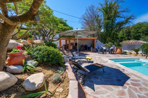 a backyard with a swimming pool and an umbrella at Villa Roma in Prunelli-di-Fiumorbo