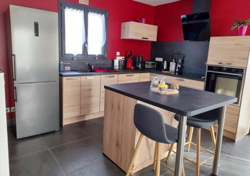 a kitchen with a refrigerator and a table with chairs at Maison de 2 chambres avec jardin clos et wifi a Coltines in Coltines