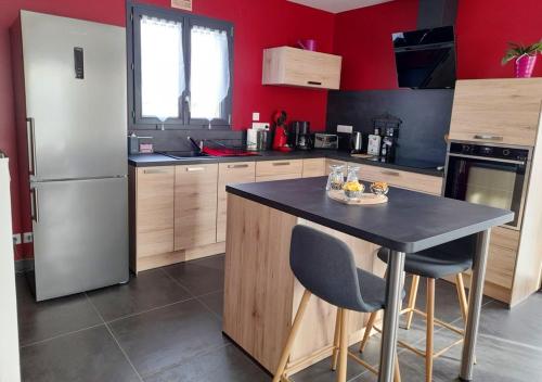 a kitchen with a refrigerator and a table with chairs at Maison confortable à Coltines 80 m² avec jardin spacieux in Coltines
