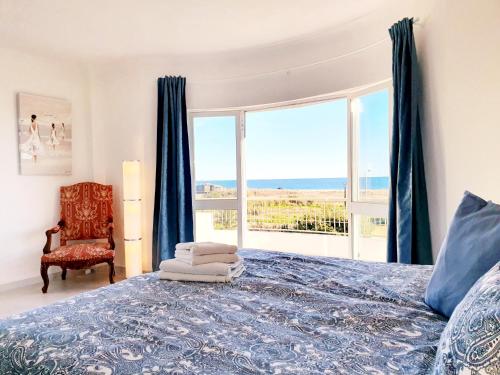 een slaapkamer met een bed en een groot raam bij Casa Cristal in Lagos