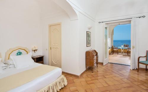 a bedroom with a bed and a view of the ocean at Hotel L'Ancora in Positano