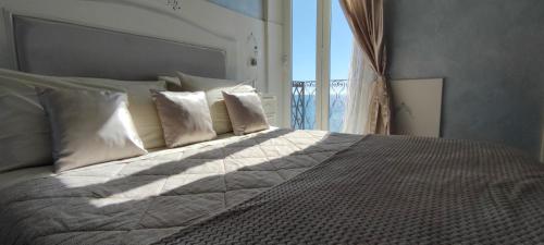 1 dormitorio con cama con almohadas y ventana en B&B DaGiueli, en Alassio