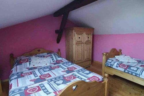 2 camas en una habitación con paredes rosas y moradas en Chalet duplex avec terrasse entièrement équipé60m2 en Gérardmer