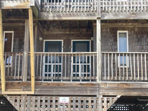 un porche delantero de una casa de madera con barandilla blanca en SW 1 STARFISH condo, en Hatteras