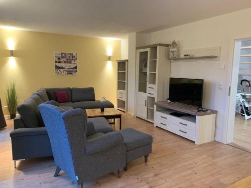 sala de estar con sofá, silla y TV en Glückshaus Peter, en Dreschvitz