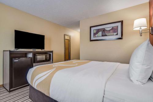 a hotel room with a large bed and a flat screen tv at Quality Inn Hastings in Hastings