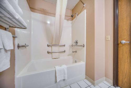 een witte badkamer met een bad en een wastafel bij Quality Inn in Hastings