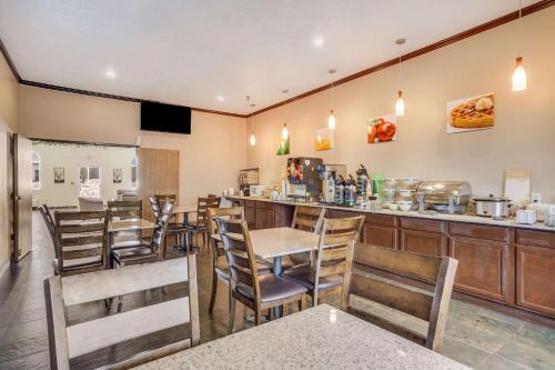a restaurant with tables and chairs and a bar at Quality Inn Hastings in Hastings