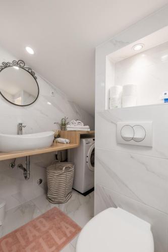 a white bathroom with a sink and a mirror at Bella Ciao Apartments in Rijeka
