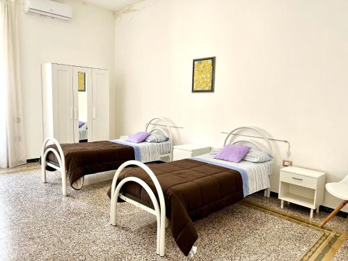 2 bedden in een kamer met paarse kussens bij Casa Vacanze Sunshine in Salerno