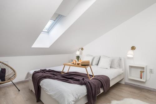 een witte slaapkamer met een bed en een tafel bij Bella Ciao Apartments in Rijeka