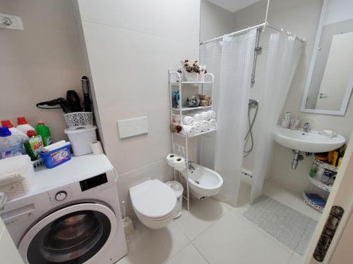 a bathroom with a washing machine and a sink at Valamar ED Apartment in Hamallë