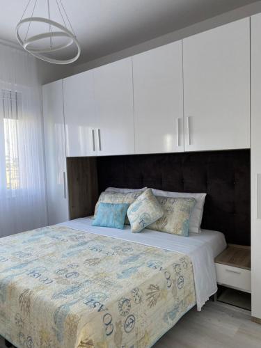 a bedroom with a large bed with white cabinets at Valamar ED Apartment in Hamallë