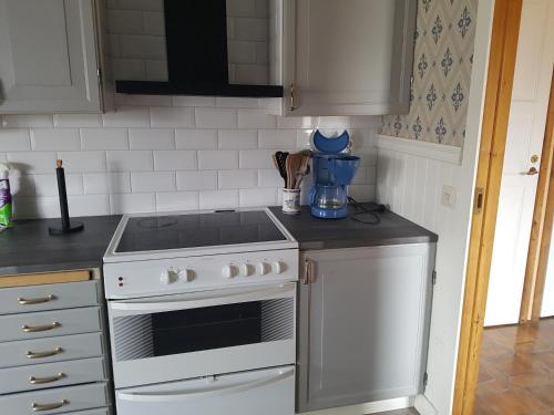 a kitchen with a stove and a white oven at Hus på landet nära sjö in Berga