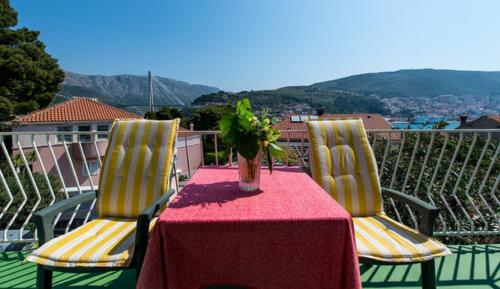 a table with two chairs and a vase on it at Guest House Mrdalo in Dubrovnik