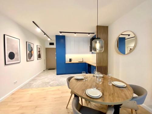 a dining room with a wooden table and chairs at Nautica Resort by Q4Apartments in Giżycko