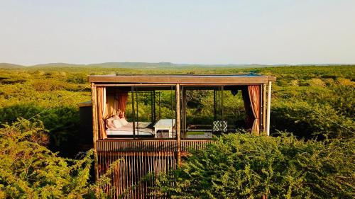 a tiny house with a person sitting on a couch at Mudhouse Zululand in Hluhluwe