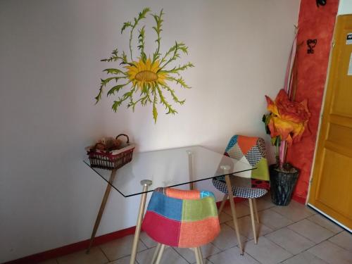 a dining room with a glass table and two chairs at Au coeur du Caylar in Le Caylar
