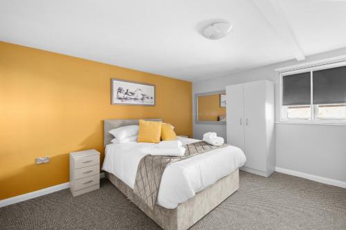 1 dormitorio con cama y pared amarilla en Still House, en Boston