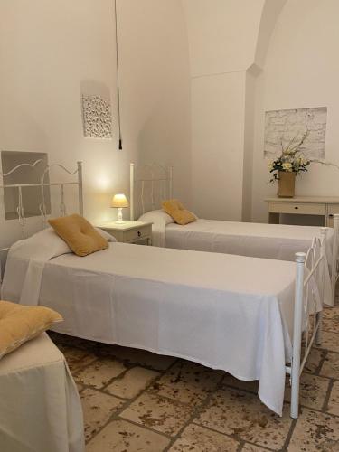 Habitación con 2 camas y 2 mesas en Masseria Palmo, en Francavilla Fontana