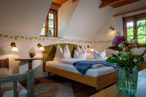 Un dormitorio con una cama con un jarrón de flores en Wirtshaus Jagawirt en Sommereben