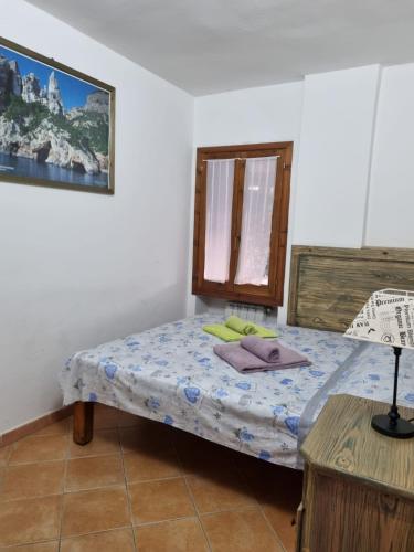 a small bedroom with a bed and a window at Appartamenti Quilici in Santa Maria Navarrese