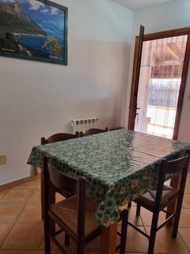 a dining room table with a green table cloth on it at Appartamenti Quilici in Santa Maria Navarrese