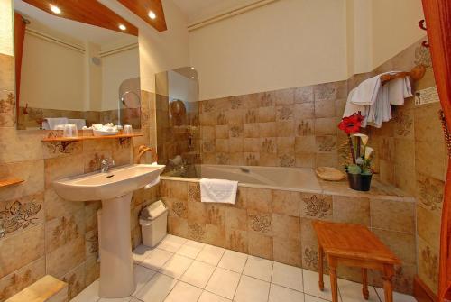 a bathroom with a sink and a bath tub at Relais Saint Roch in Saint-Alban-sur-Limagnole