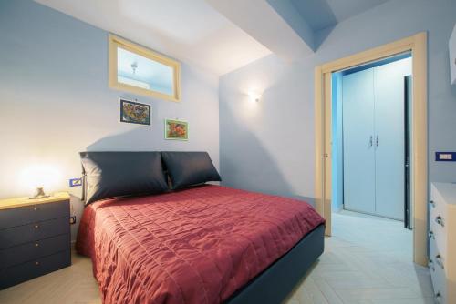 um quarto com uma cama com uma colcha vermelha em casa claudia Two rooms overlooking the sea bk em Procida