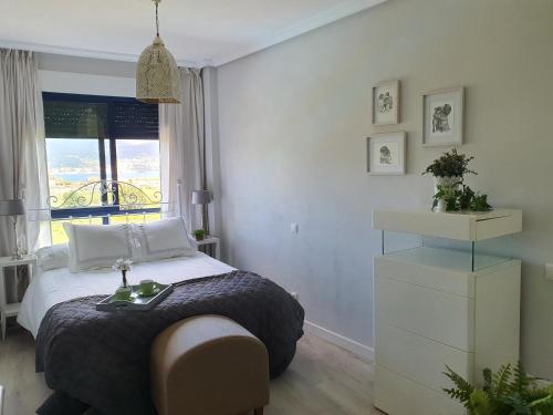 a bedroom with a bed and a window at Apartamento con piscina en Boiro - Cabo de Cruz in Boiro