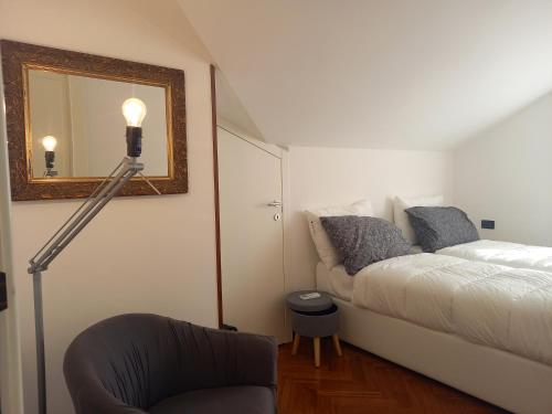 a bedroom with a bed and a mirror and a chair at La Principessa Nera B&B in Ostra