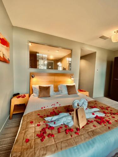 une chambre avec un lit avec des fleurs rouges dessus dans l'établissement Hôtel et SPA du Château, à Lagord