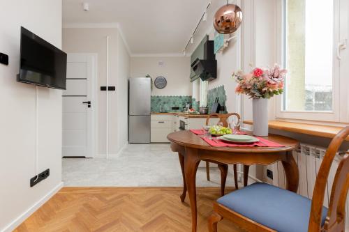 a kitchen and dining room with a table with flowers on it at Apartment Warsaw Wiktorska by Renters in Warsaw