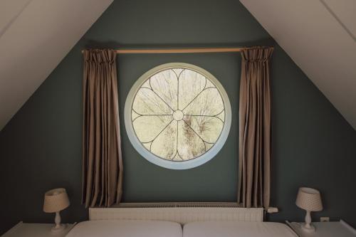 a large clock on a green wall in a bedroom at 't Uilengat 6-8 persoons appartement in Retranchement