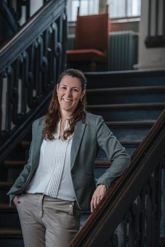 a woman in a green jacket standing on stairs at Boutique-Hotel Rüden in Schaffhausen