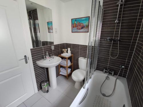 a bathroom with a toilet and a sink and a tub at Sea Dragon in Rye