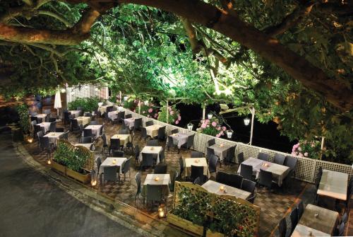 a restaurant with tables and chairs on the street at Kentrikon Hotel in Lagadia