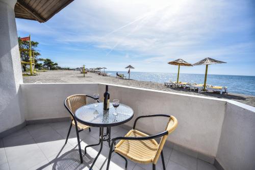 a table and chairs on a balcony overlooking the beach at FKK Ada Bojana in Ulcinj