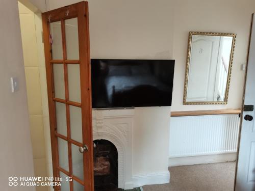 a flat screen tv above a fireplace in a room at Lincoln House in Bournemouth