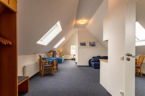 an attic room with a living room and a dining room at Dorint Parkhotel Siegen in Siegen